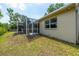 Spacious screen patio features overhead lighting and a ceiling fan, overlooking the grassy backyard at 5623 Wilde Oak Way, Sarasota, FL 34232