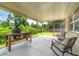 Screened-in patio with barbecue and outdoor seating providing a relaxing view of the backyard at 5623 Wilde Oak Way, Sarasota, FL 34232
