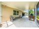 Covered, screened-in patio offers relaxing backyard views with an outdoor grill, comfortable seating, and ample space at 5623 Wilde Oak Way, Sarasota, FL 34232