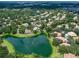 Aerial view of a residential community featuring tree-lined streets and a tranquil lake, offering a peaceful setting at 5729 Garden Lakes Palm, Bradenton, FL 34203