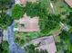 Aerial view of a home with a tile roof, surrounded by trees, lawn and close to a pond at 5729 Garden Lakes Palm, Bradenton, FL 34203