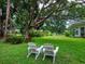 Inviting backyard with comfortable Adirondack chairs, perfect for relaxing and enjoying the peaceful outdoor setting at 5729 Garden Lakes Palm, Bradenton, FL 34203