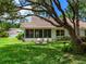Beautiful backyard with lush lawn, shade trees and a tiled roof home with screened in porch at 5729 Garden Lakes Palm, Bradenton, FL 34203