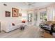 Bright living room with a white sofa, light wood floors, and sliding glass doors to a screened porch at 5729 Garden Lakes Palm, Bradenton, FL 34203