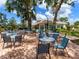 Outdoor patio with tables and chairs, surrounded by lush greenery, perfect for relaxing at 5729 Garden Lakes Palm, Bradenton, FL 34203