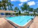 Community pool surrounded by trees and lounge chairs, perfect for relaxation at 5729 Garden Lakes Palm, Bradenton, FL 34203