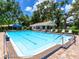 Outdoor community pool with clear blue water, surrounded by lush trees and various seating options at 5729 Garden Lakes Palm, Bradenton, FL 34203