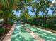 Community shuffleboard courts surrounded by mature trees and lush greenery, a great place for leisure at 5729 Garden Lakes Palm, Bradenton, FL 34203