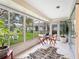 Cozy sunroom with tile flooring, outdoor seating, and panoramic views of the backyard at 5729 Garden Lakes Palm, Bradenton, FL 34203