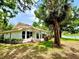 Lawn leading to a pond behind this single-story home, with lots of shade from mature trees at 5810 Garden Lakes Palm, Bradenton, FL 34203