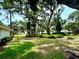 Spacious backyard with lush green grass and mature trees, offering plenty of room to roam and play at 5810 Garden Lakes Palm, Bradenton, FL 34203
