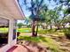 View of a nice lawn, a pond, and houses in the distance through the trees from the back patio at 5810 Garden Lakes Palm, Bradenton, FL 34203