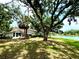 A single-story house with a lawn that goes all the way down to the pond, with plenty of large, mature trees at 5810 Garden Lakes Palm, Bradenton, FL 34203