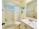 Well-lit bathroom featuring a tub with shower and updated vanity with decorative nautical accents at 5810 Garden Lakes Palm, Bradenton, FL 34203
