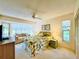 Bedroom with large window, ceiling fan, and cozy seating area at 5810 Garden Lakes Palm, Bradenton, FL 34203