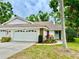 Charming single-story home with a well-maintained lawn, a two-car garage, and beautiful landscaping at 5810 Garden Lakes Palm, Bradenton, FL 34203