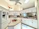 Well-lit kitchen featuring white cabinets, granite countertops, modern appliances, and an island at 5810 Garden Lakes Palm, Bradenton, FL 34203