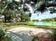 Peaceful pond view from a shaded seating area showcasing waterfront living at 5810 Garden Lakes Palm, Bradenton, FL 34203