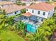 Aerial view of home with a screened pool, lush greenery, and a red tile roof at 5823 Title Row Dr, Bradenton, FL 34210