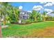 Landscaped backyard featuring a lawn, lush greenery, and a screened pool area at 5823 Title Row Dr, Bradenton, FL 34210