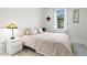 Cozy bedroom featuring natural light, a decorative lamp, and minimalist decor for a serene atmosphere at 5823 Title Row Dr, Bradenton, FL 34210