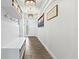 Bright entryway featuring a wood-look floor, a white bench, and decorative wall hooks, perfect for storage at 5823 Title Row Dr, Bradenton, FL 34210