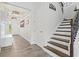 Welcoming entryway with wood-look tile floors, staircase, and stylish light fixtures at 5823 Title Row Dr, Bradenton, FL 34210