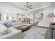 Bright, open-concept living room featuring a large sectional sofa, ceiling fan, and hardwood floors at 5823 Title Row Dr, Bradenton, FL 34210