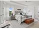 Bright main bedroom with tray ceilings, wood-look floors, a chest, and ample natural light at 5823 Title Row Dr, Bradenton, FL 34210
