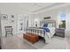 Bright main bedroom with tray ceilings, wood-look floors, a chest, and ample natural light at 5823 Title Row Dr, Bradenton, FL 34210