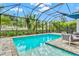 Screened pool with stone surround and lush landscaping offers a private, tropical oasis at 5823 Title Row Dr, Bradenton, FL 34210