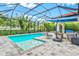 Relaxing screened-in pool area with a spa, seating, and lush landscaping at 5823 Title Row Dr, Bradenton, FL 34210