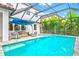 The screened pool and attached spa feature an umbrella and seating area, perfect for relaxation at 5823 Title Row Dr, Bradenton, FL 34210