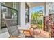 Cozy front porch featuring wicker chairs and a view of palm trees and blue skies at 5823 Title Row Dr, Bradenton, FL 34210