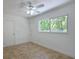 Bright bedroom with tile floors, white walls, a door to the side, and large sunny window at 5920 Gulf Of Mexico Dr, Longboat Key, FL 34228