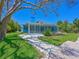 Charming blue home featuring a screened lanai and lush landscaping, creating a serene outdoor space at 5920 Gulf Of Mexico Dr, Longboat Key, FL 34228