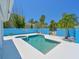 Pool and hot tub surrounded by blue fencing and tropical plants in a private backyard retreat at 5920 Gulf Of Mexico Dr, Longboat Key, FL 34228