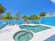 An above angle of the pool and hot tub surrounded by a concrete patio and blue fencing for privacy at 5920 Gulf Of Mexico Dr, Longboat Key, FL 34228