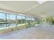 Bright sunroom featuring tile flooring, ceiling fans, and expansive windows offering waterfront views at 5920 Gulf Of Mexico Dr, Longboat Key, FL 34228