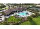 Aerial view of the community pool and clubhouse, complete with outdoor seating, tennis courts, and beautiful landscaping at 5987 Snowy Egret Dr, Sarasota, FL 34238