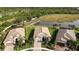 Aerial view of homes with well-maintained landscaping, driveways, and a serene pond in the background at 5987 Snowy Egret Dr, Sarasota, FL 34238