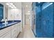 Stylish bathroom features a blue mosaic-tiled shower with glass door and updated vanity at 5987 Snowy Egret Dr, Sarasota, FL 34238