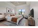 Beautiful bedroom with a tray ceiling, ceiling fan, comfy bed, and scenic outdoor view at 5987 Snowy Egret Dr, Sarasota, FL 34238