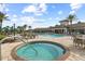 Stunning community pool featuring a relaxing hot tub, lounge chairs, and lush tropical landscaping at 5987 Snowy Egret Dr, Sarasota, FL 34238