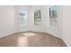 Bright empty room with light wood flooring and shuttered windows providing natural light at 5987 Snowy Egret Dr, Sarasota, FL 34238
