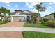 Beautiful home featuring a well maintained lawn, elegant landscaping, and a brick driveway at 5987 Snowy Egret Dr, Sarasota, FL 34238