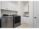 Well-equipped laundry room with modern washer and dryer, plus additional storage cabinets at 5987 Snowy Egret Dr, Sarasota, FL 34238