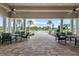 Covered patio with tables, chairs, ceiling fans, and columns, providing a relaxing spot to enjoy the view of the pool at 5987 Snowy Egret Dr, Sarasota, FL 34238