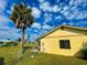 The property has a palm tree, a fenced yard with a lawn under a partly cloudy sky at 6113 Mckee St, Port Charlotte, FL 33981