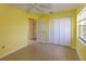 The bright bedroom features a large window, tiled floors, and closet for plenty of storage at 6113 Mckee St, Port Charlotte, FL 33981